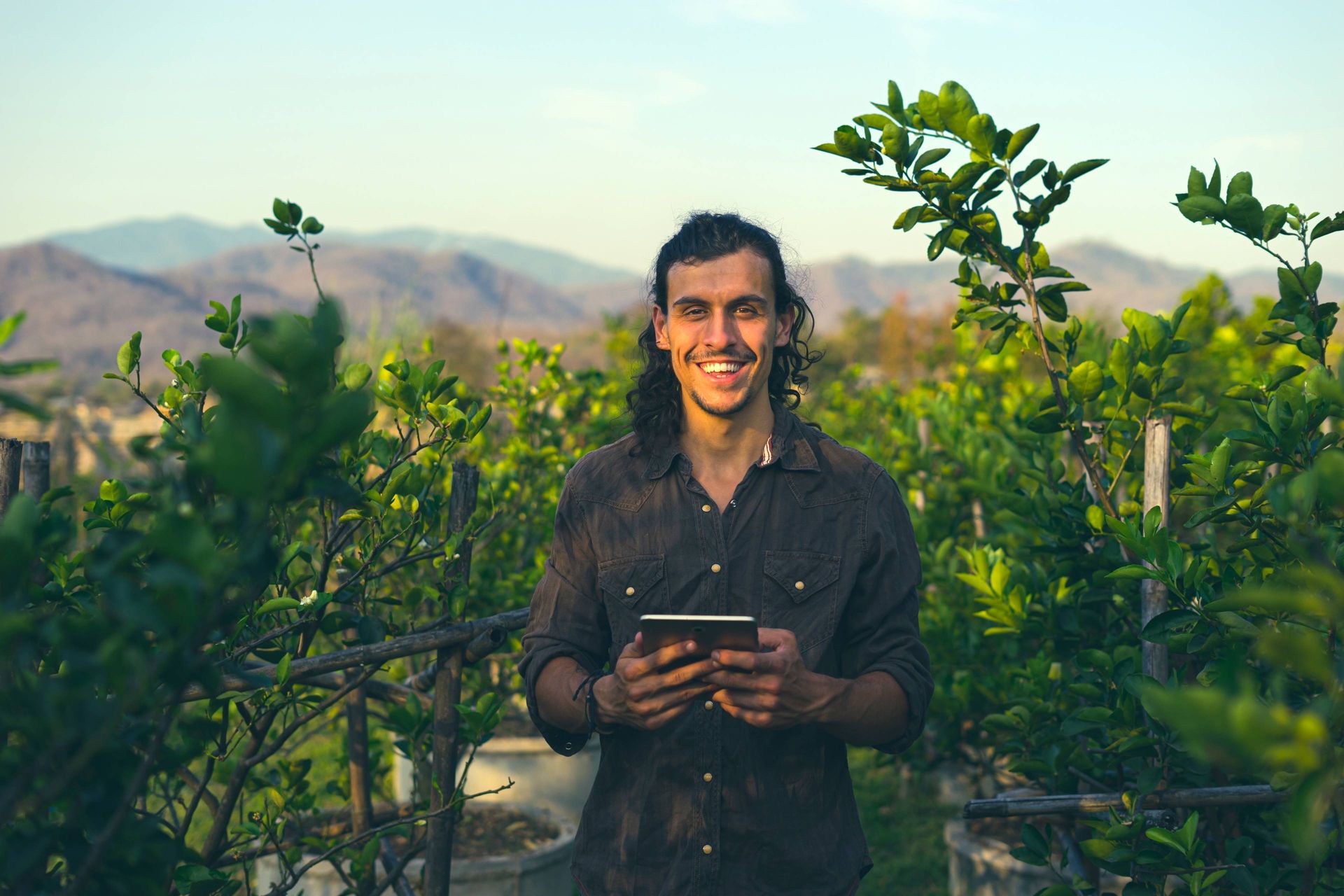 Image of a producer in a field monitoring environmental metrics