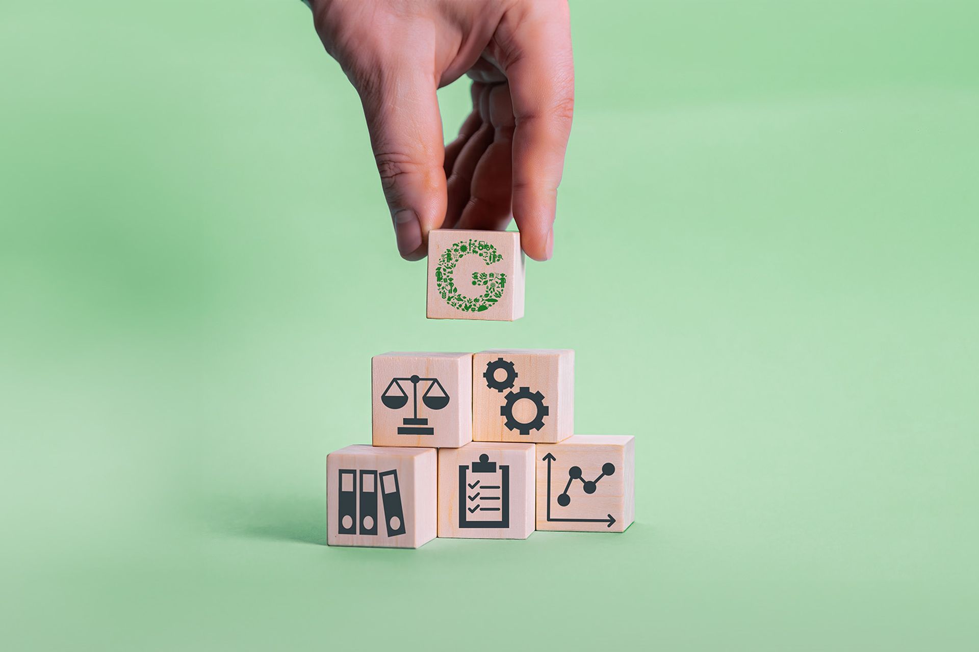 Image of a person assembling wooden blocks that represent the activities of the GLOBALG.A.P. Integrity Program